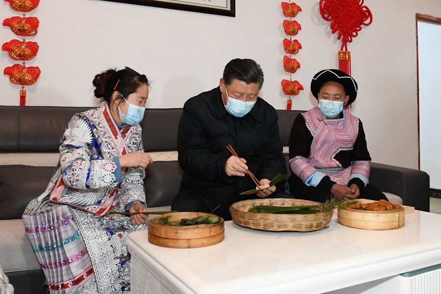 2021年2月3日下午，習(xí)近平在貴州畢節(jié)市黔西縣新仁苗族鄉(xiāng)化屋村苗族村民趙玉學(xué)家，同一家人邊聊家常邊制作當(dāng)?shù)貍鹘y(tǒng)節(jié)日食品黃粑。新華社記者 李學(xué)仁 攝