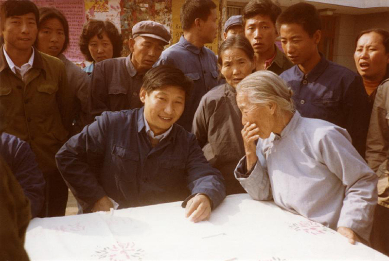 1983年，時(shí)任河北正定縣委書記的習(xí)近平（前排居中），臨時(shí)在大街上擺桌子聽取老百姓意見。